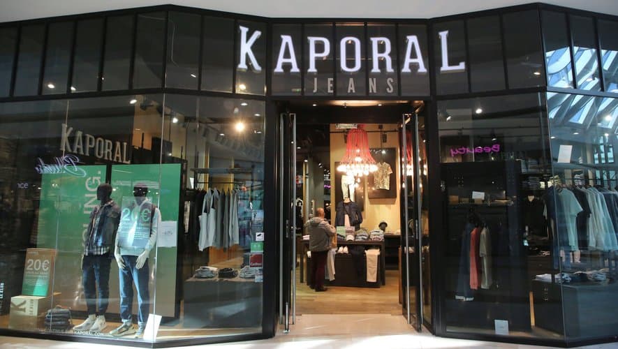 Enseigne Kaporal Jean sur une vitrine de prêt-à-porter