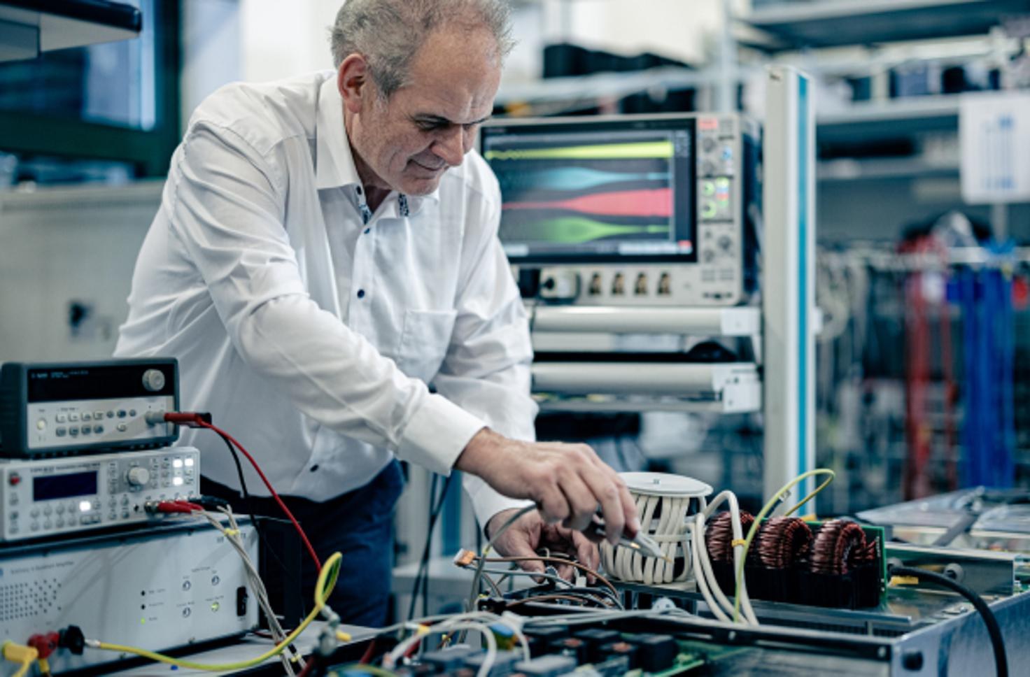 Ingénieur Alpitronic travaillant sur des composants d'électronique de puissance en laboratoire