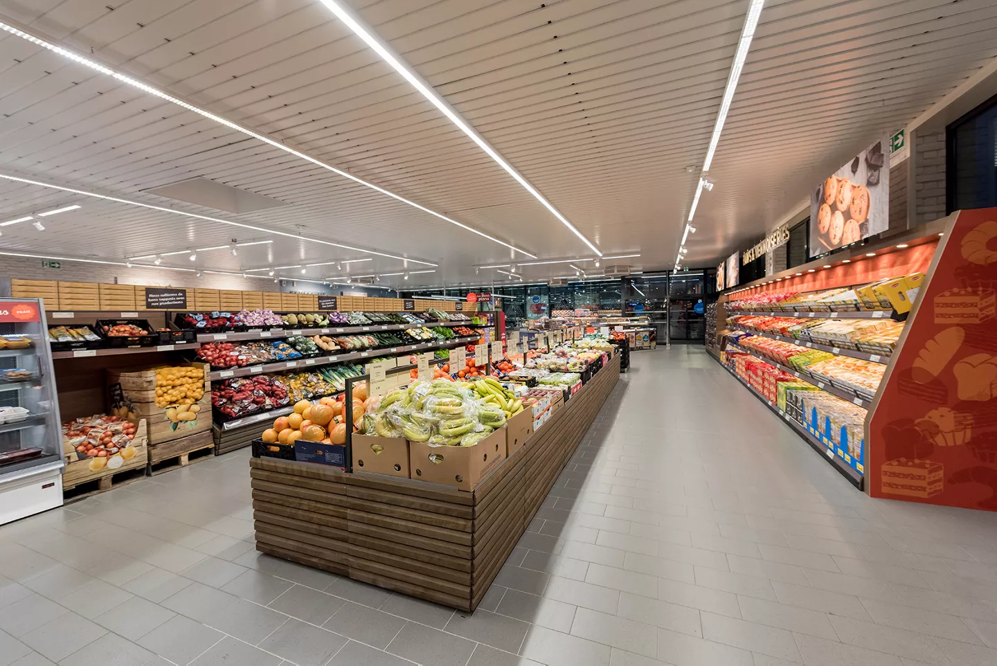 Rayon fruits, légumes et pains d'un magasin ALDI France modernisé