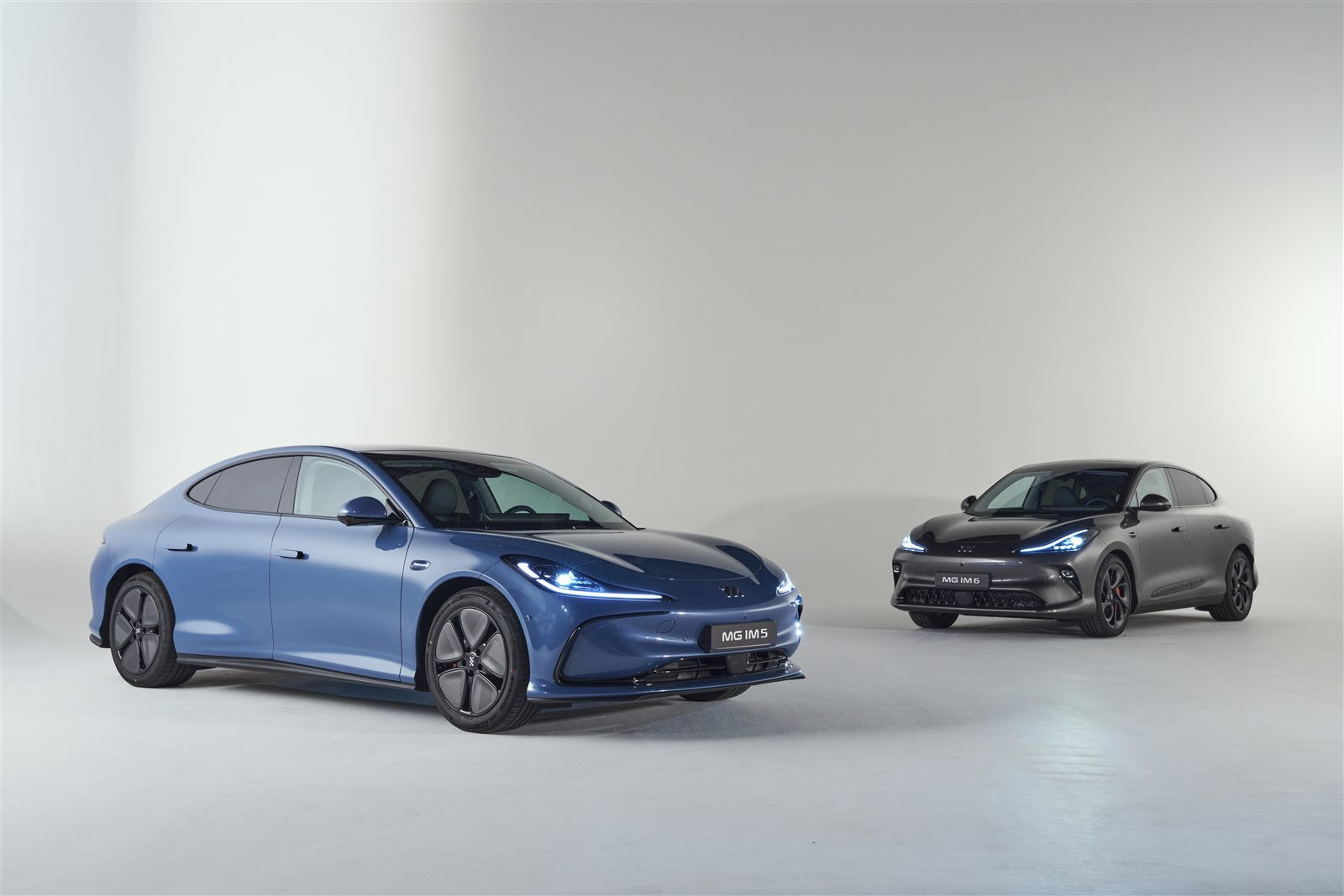Berline MG IM5 bleue et SUV MG IM6 gris présentés ensemble en studio