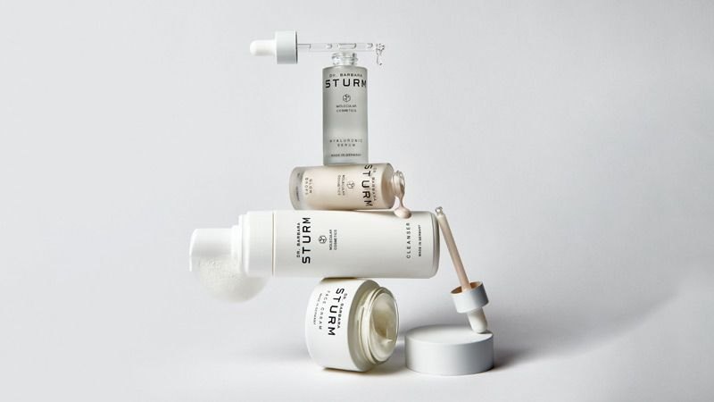 Produits de soin Dr. Barbara Sturm disposés sur un fond minéral clair